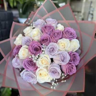 Bouquet of pastel roses wrapped in pink-edged paper