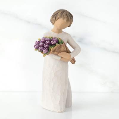 Figurine of a girl holding a bouquet of purple tulips