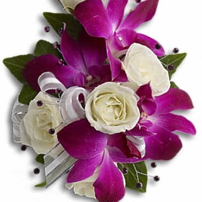 White roses and purple orchids arranged in a compact bouquet