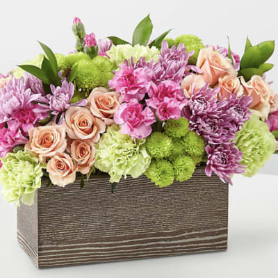 Mixed pink and green flower arrangement in a wooden box