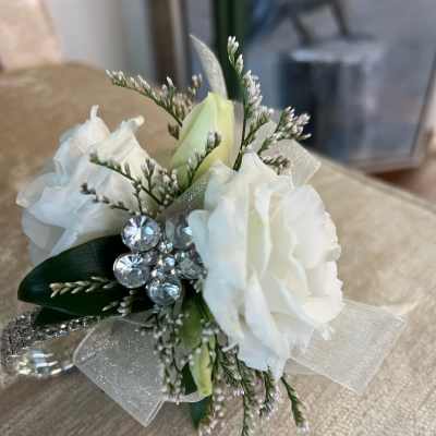 Small white rose corsage with rhinestone accents and sheer ribbon