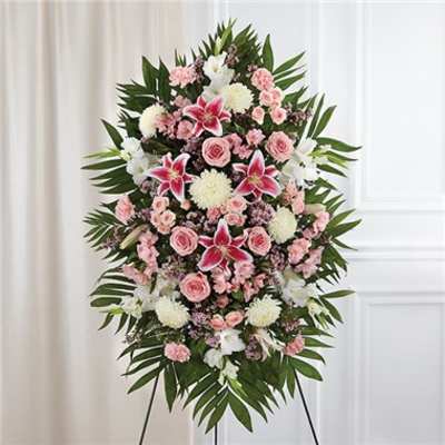 Tall pink and white standing spray with lilies, roses, carnations, and mums on an easel