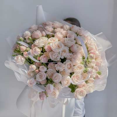 Large bouquet of pale pink roses wrapped in white paper