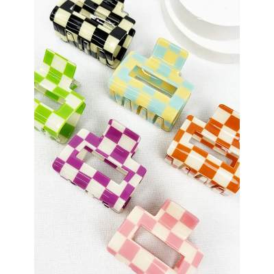 Colorful checkered hair clips on a white surface