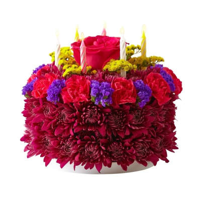 Round floral cake of red and purple blooms topped with a rose and birthday candles