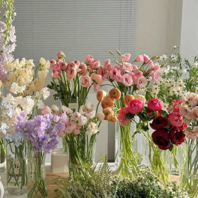 Assorted pastel flower bouquets in glass vases on a table