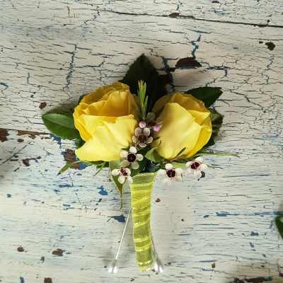 Yellow rose boutonniere with small white accent flowers and ribbon