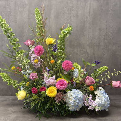 Large mixed floral arrangement with pink, yellow, blue, and green blooms