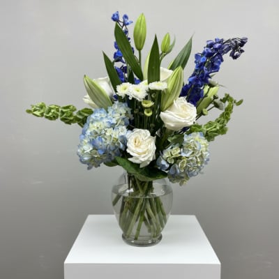 Blue and white floral arrangement in a clear glass vase