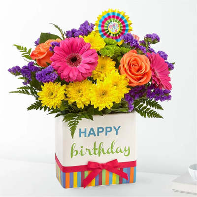 Birthday bouquet in a decorated gift box with pink, yellow, orange, and purple flowers
