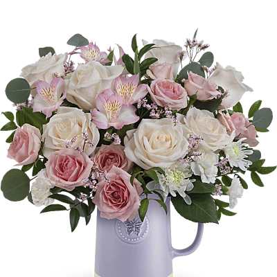 Pink and white roses arranged in a lavender pitcher vase