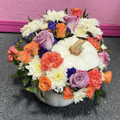Pumpkin-shaped centerpiece with mixed roses, carnations, and white daisies