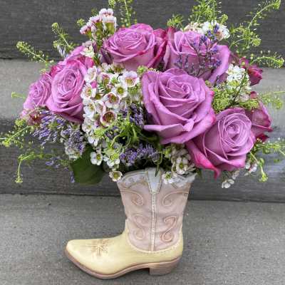 Pink rose bouquet arranged in a decorative cowboy boot