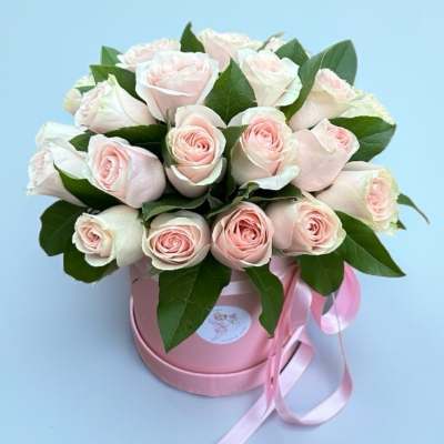 Bouquet of pale pink roses in a pink round box with ribbon