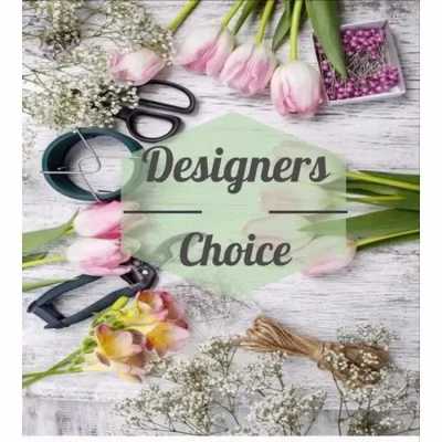 Flat lay of pink tulips, filler flowers, and florists' tools around a Designers Choice label