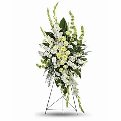 Standing floral spray of white and pale green flowers on a metal easel