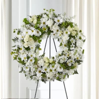 White floral wreath on a black easel