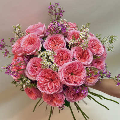 Pink rose bouquet with small purple and white filler flowers