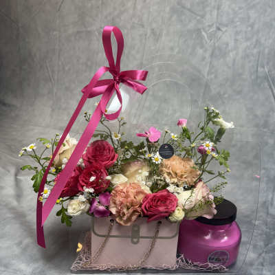 Mixed pink and peach flowers in a gift box with a ribbon