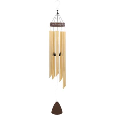 Tall gold metal wind chime with brown accents hanging from a white hook.