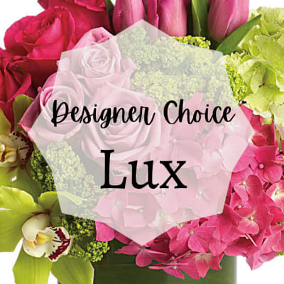Lush pink and green flower arrangement with roses, tulips, orchids, and hydrangeas in a green vase
