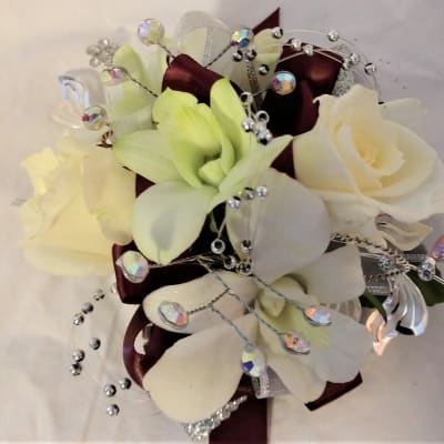 White roses and pale lilies with jeweled ribbon accents