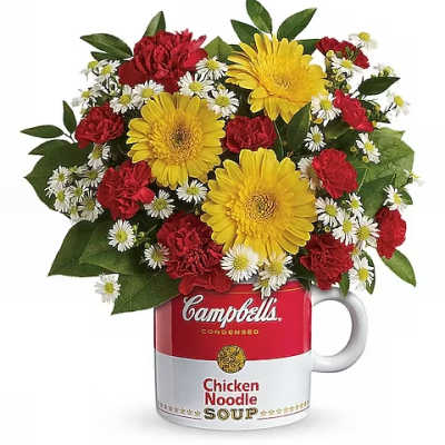 Bouquet of red and yellow flowers in a Campbell's soup mug