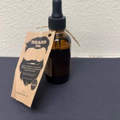 Amber dropper bottle labeled beard oil with a hanging tag