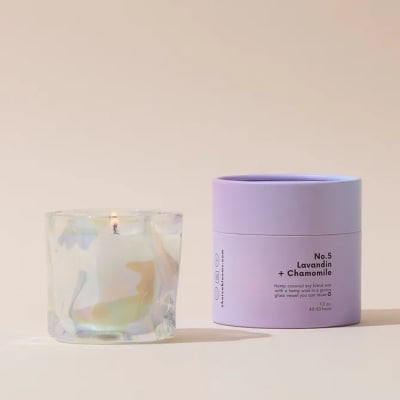 Lavender candle in a glass vessel beside its box