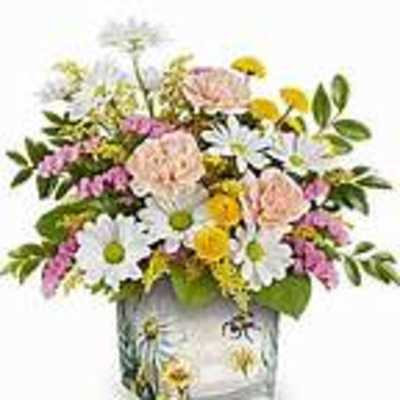 Mixed bouquet of daisies, carnations, and yellow blooms in a glass vase