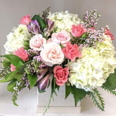Pink roses and white hydrangeas in a white vase