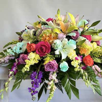 Large colorful floral arrangement with roses and lilies on a table