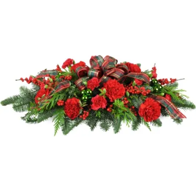 Red carnations and berries arranged with plaid ribbon on evergreen