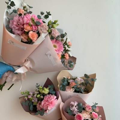 Five pastel flower bouquets wrapped in pink paper