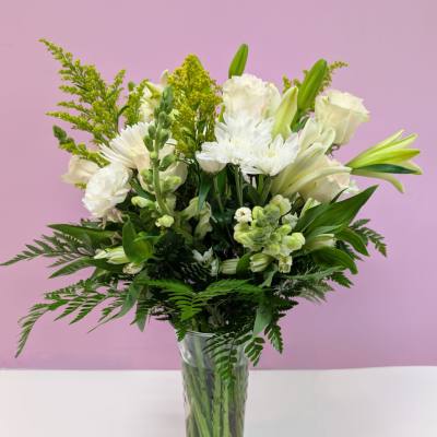 White lilies and chrysanthemums in a clear glass vase