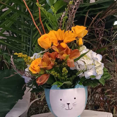 Bouquet of orange and white flowers in a cat-shaped planter