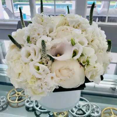 White floral bouquet with calla lilies and hydrangeas in a white vase