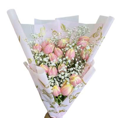 Bouquet of pink tulips with white baby's breath in pastel wrapping