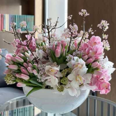 Pink and white floral arrangement in a white bowl vase
