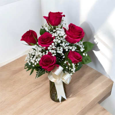 Bouquet of red roses with white baby's breath in a glass vase