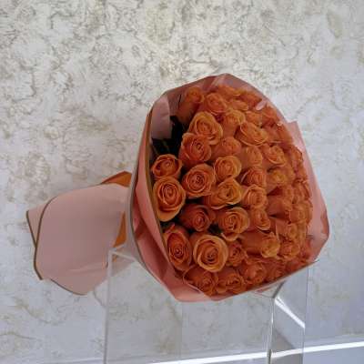 Bouquet of orange roses wrapped in pink paper