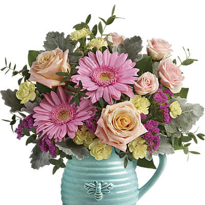 Pink gerbera daisies and peach roses in a turquoise mug vase