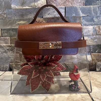Brown handbag with a glittery red flower charm and small cardinal figurine