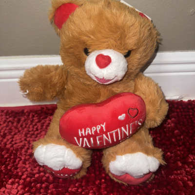 Brown teddy bear holding a red heart with "Happy Valentine's" text