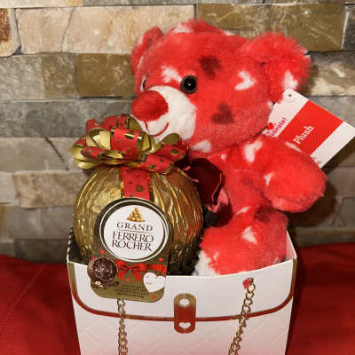 Red teddy bear with a Ferrero Rocher chocolate gift in a white box