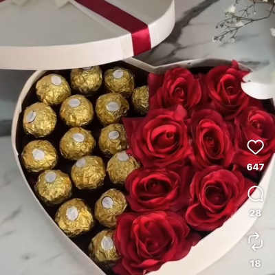 Heart-shaped box with red roses and gold-wrapped chocolates