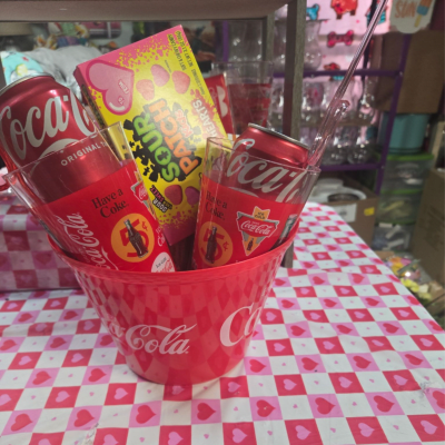 Coca-Cola cans and candy in a pink heart-patterned bucket