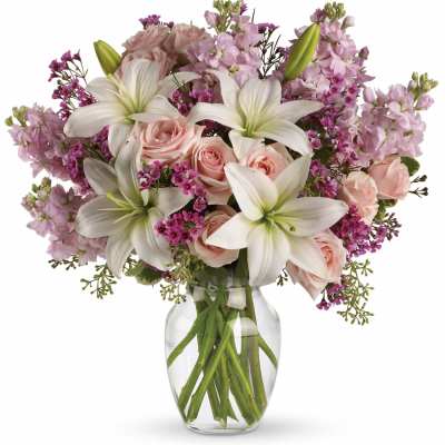 Pink roses and white lilies arranged in a clear glass vase