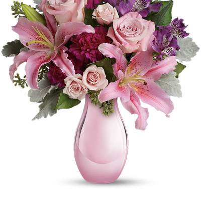 Pink lilies, roses, and purple flowers in a pink vase