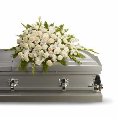 White rose and lily casket spray arranged on a silver casket